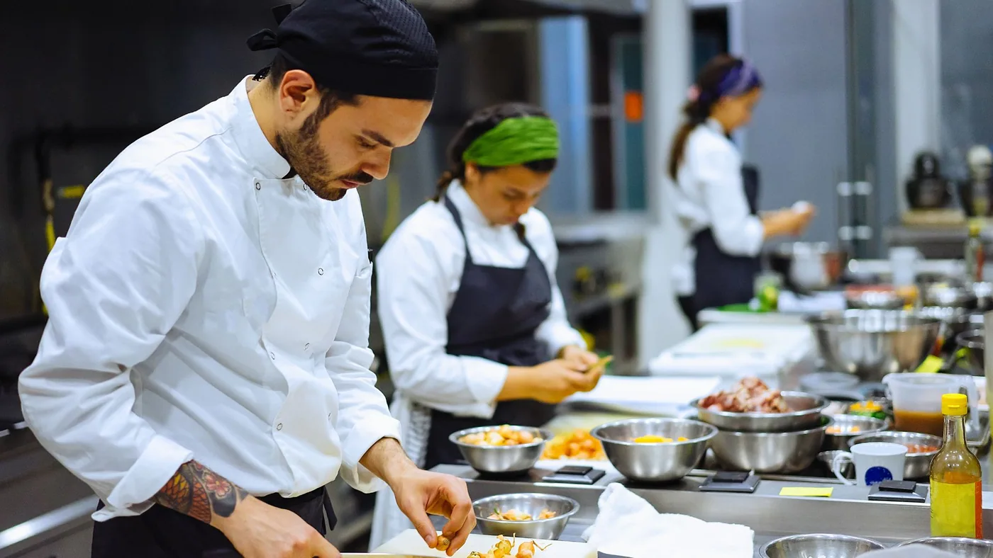 Equipo preparando pedidos en una cocina profesional
